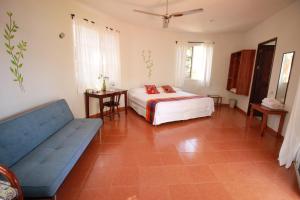 a bedroom with a bed and a couch and a table at Eco-Hotel Nueva Altia in Santa Elena