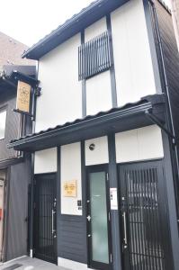 a black and white building with black doors at Stay SAKURA Kyoto Toji South II in Kyoto