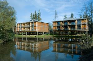 zwei Gebäude neben einem Wasserkörper in der Unterkunft Domaine de Cicé-Blossac, Resort Spa & Golf in Bruz