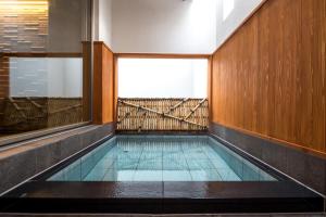 a swimming pool in a building with a balcony at Hotel Munin Furano in Furano