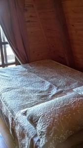 Hogar de la luna في مونتي كاسيروس: سرير في غرفة ذات سقف خشبي