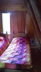 Hogar de la luna في مونتي كاسيروس: غرفة نوم بسرير في كابينة خشبية