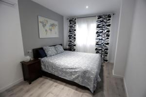 Schlafzimmer mit einem Bett und einem Fenster in der Unterkunft Brand new charming apartment next to the river in Sevilla