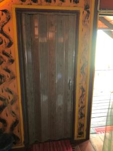 a wooden door in a room with a wall at Beach Shack Chalet - Garden View Aframe Big Unit in Tioman Island