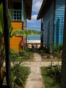 a pathway leading to a beach with a house and the ocean at Beach Shack Chalet - Garden View Aframe Big Unit in Tioman Island