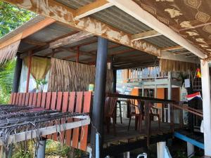 een paviljoen met stoelen en tafels op een veranda bij Beach Shack Chalet - Garden View Aframe Big Unit in Tioman Island
