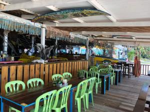 a restaurant with green chairs and tables and a bar at Beach Shack Chalet - Garden View Aframe Big Unit in Tioman Island