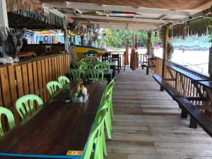 a restaurant with green chairs and a wooden table at Beach Shack Chalet - Garden View Aframe Big Unit in Tioman Island