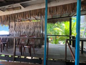 a restaurant with chairs and a table and a thatched roof at Beach Shack Chalet - Garden View Aframe Big Unit in Tioman Island
