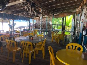 a restaurant with tables and yellow chairs and tables at Beach Shack Chalet - Garden View Aframe Big Unit in Tioman Island