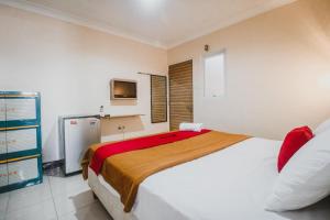 - une chambre avec un grand lit et une télévision dans l'établissement RedDoorz @ Pandu Raya Bogor, à Bogor