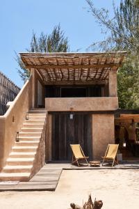 a house with two folding chairs and stairs at The Island Houses Gili Meno in Gili Meno