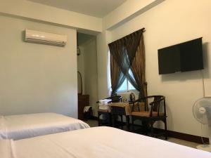 卑南台東耿家莊民宿的一间配有两张床、一张桌子和一台电视的酒店房间