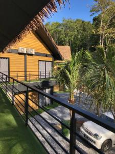 une voiture garée devant un bâtiment jaune dans l'établissement A Coral Reefs Resort Langkawi, à Kuah