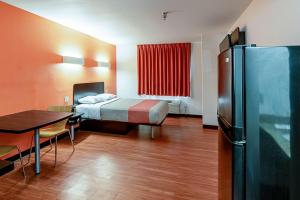 a room with a bed and a table and a refrigerator at Motel 6-Lebanon, IN in Lebanon