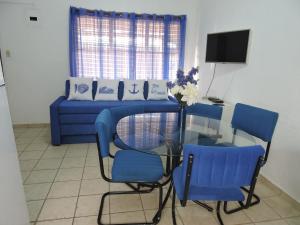 a living room with a glass table and blue chairs at Alquiler de Villas - Condominio en Jacó in Jacó
