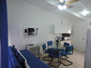 un soggiorno con divano blu, tavolo e sedie di Alquiler de Villas - Condominio en Jacó a Jacó