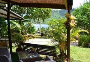 a view of a park with a bench and plants at Te Fare Hinahei in Moorea