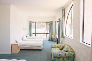 a living room with two beds and a couch at Aquarius Merimbula in Merimbula