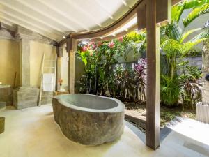 a bath tub in a room with plants at Akilea Villas in Uluwatu