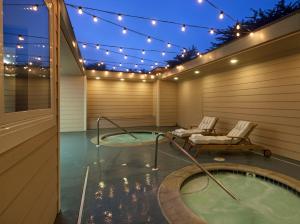 eine Whirlpool-Badewanne auf einer Terrasse mit Licht in der Unterkunft Cambria Landing Inn and Suites in Cambria