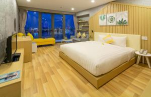 a bedroom with a bed and a living room at Happy Day Hotel & Spa in Danang