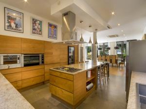 a kitchen with wooden cabinets and a large island at Akilea Villas in Uluwatu
