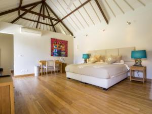 a bedroom with a large bed and a table at Akilea Villas in Uluwatu