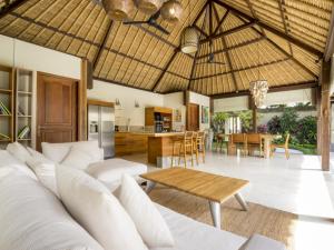 an open living room with a couch and a table at Akilea Villas in Uluwatu