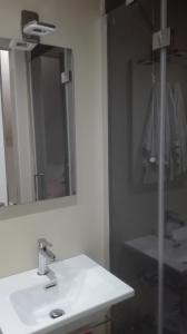 bagno con lavandino bianco e specchio di Cocciopestorooms a Marina di Massa