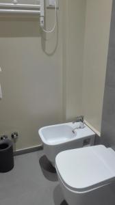 a bathroom with a white toilet and a sink at Cocciopestorooms in Marina di Massa