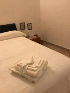 Ein weißer Bademantel liegt auf einem weißen Bett. in der Unterkunft Parva Domus in Matera