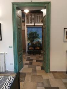 una puerta abierta que conduce a un comedor con mesa en Casina San Gregorio Apartment, en Nápoles