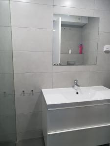 a white bathroom with a sink and a mirror at WindRose 0 in Madrid