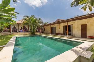 an image of a swimming pool in front of a house at Villa Pilou Boutique Hotel in Tanah Lot