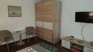 een woonkamer met een televisie en een tafel en stoelen bij Ferienwohnung oder Studio Dresden-Neustadt inkl Parkplatz mit Balkon oder Terrasse in Dresden