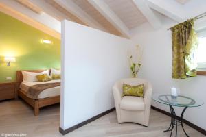 ein Schlafzimmer mit einem Bett, einem Tisch und einem Stuhl in der Unterkunft B&B Armonie del Lago in Annone di Brianza