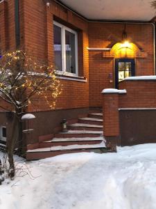 a brick house with stairs in the snow at Guest house Dobrynya in Velikiy Novgorod