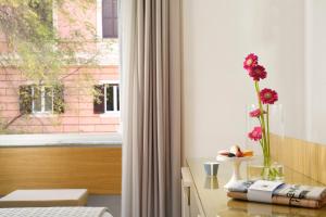 Pokój z oknem z wazą z kwiatami na stole w obiekcie Magica Luna Boutique Hotel - Roma w Rzymie +21 zdjęć