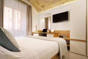 sypialnia z łóżkiem, biurkiem i telewizorem w obiekcie Magica Luna Boutique Hotel - Roma w Rzymie