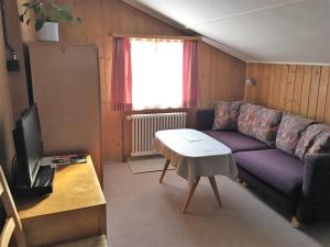 アローザにあるChalet Waldesruh 2 Zimmerwohnungのリビングルーム(紫色のソファ、テレビ付)