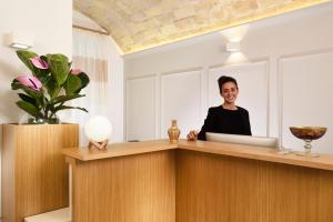 a woman sitting at a desk with a laptop at Magica Luna Boutique Hotel - Roma in Rome