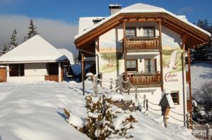 un lodge de esquí con nieve en el suelo en Chalet alla Cascata, en Badia