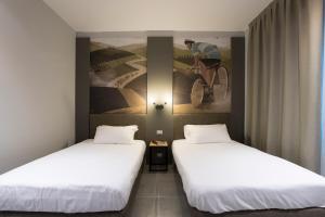 two beds in a room with a painting on the wall at Mathis in Fiorenzuola dʼArda