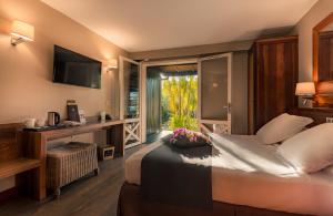 a hotel room with a bed and a large window at Iloha Seaview Hotel in Saint-Leu