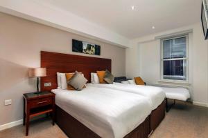 a large bedroom with a large bed and a window at Stewart by Heeton Concept - Aparthotel Edinburgh in Edinburgh
