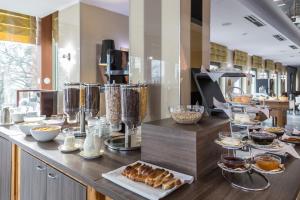 a buffet line with pastries and other food items at Holiday Beach Budapest Wellness Hotel with Sauna Park in Budapest