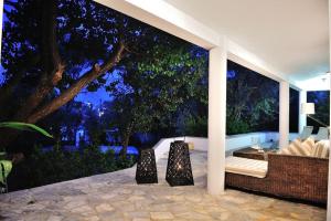 un patio esterno con divano, sedie e un albero di Villa Ftelia a Città di Skiathos