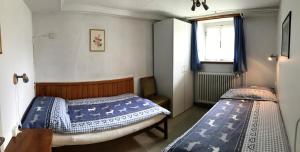 2 łóżka pojedyncze w pokoju z oknem w obiekcie Chalet Waldesruh 3 Zimmerwohnung w mieście Arosa