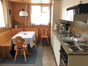 uma cozinha com uma mesa com uma toalha de mesa branca em Chalet Waldesruh 3 Zimmerwohnung em Arosa